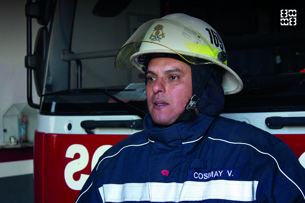 un joven bombero adulto que salva a la gente del fuego usando
